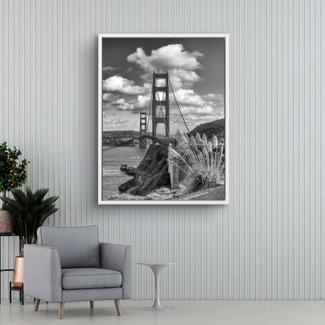Schwarzweiß Wandbild Golden Gate Bridge über Wasser mit Wolken im modernen Wohnzimmer