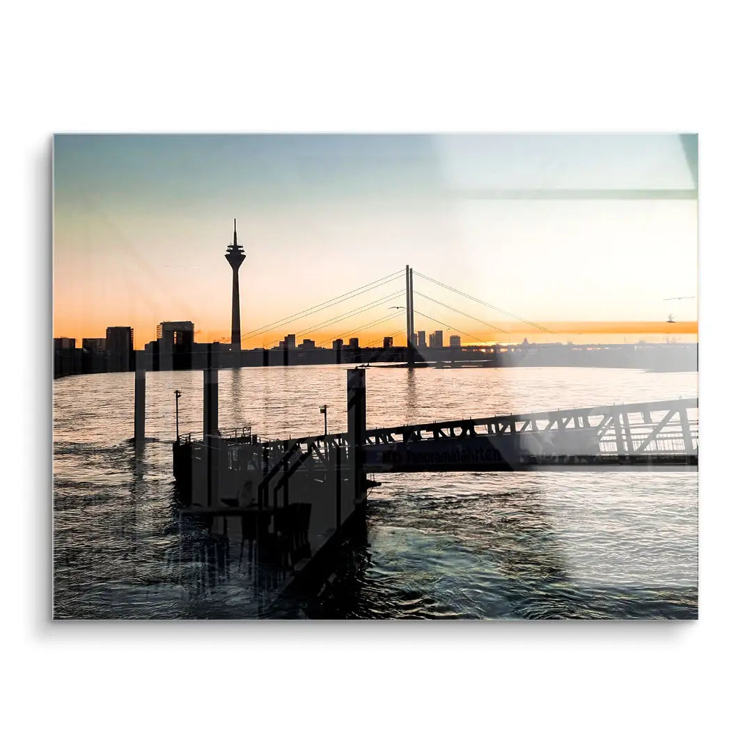 Wandbild mit Fluss, Brücke und Stadtsilhouette bei Sonnenuntergang, moderne Acrylkunst