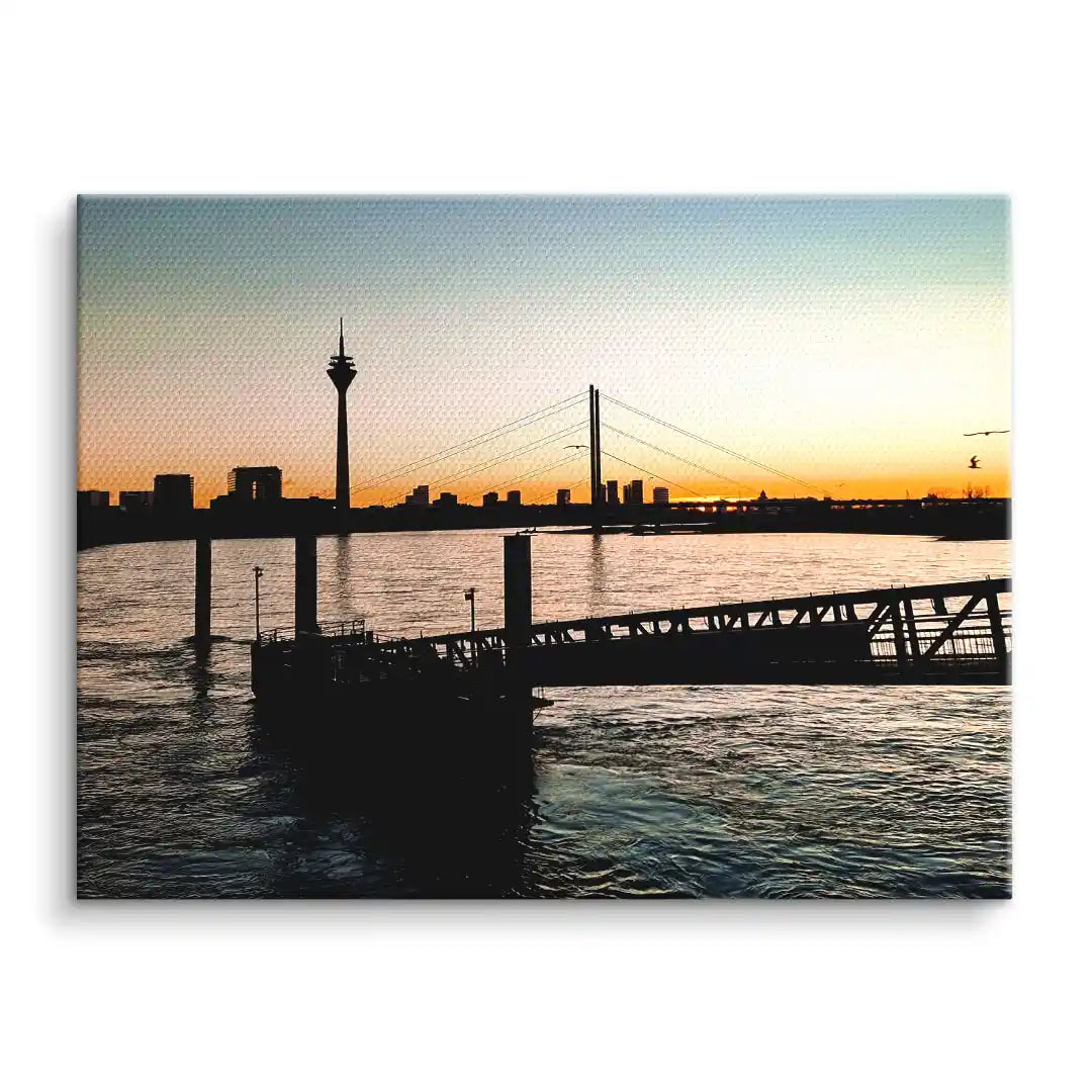 Wandbild mit Sonnenuntergang am Fluss, Skyline und Brücke, modernes Leinwandbild