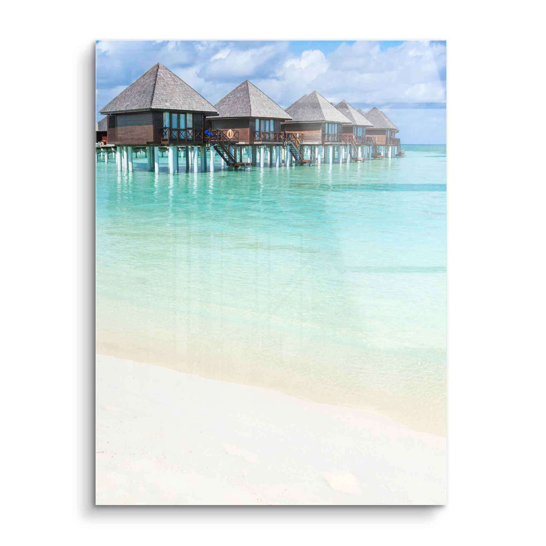 Wandbild mit tropischem Strand, türkisfarbenem Meer und Holzvillen auf Stelzen
