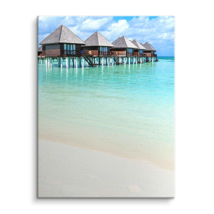 Wandbild mit tropischem Meer, Pfahlbauten und türkisblauem Wasser auf Leinwand
