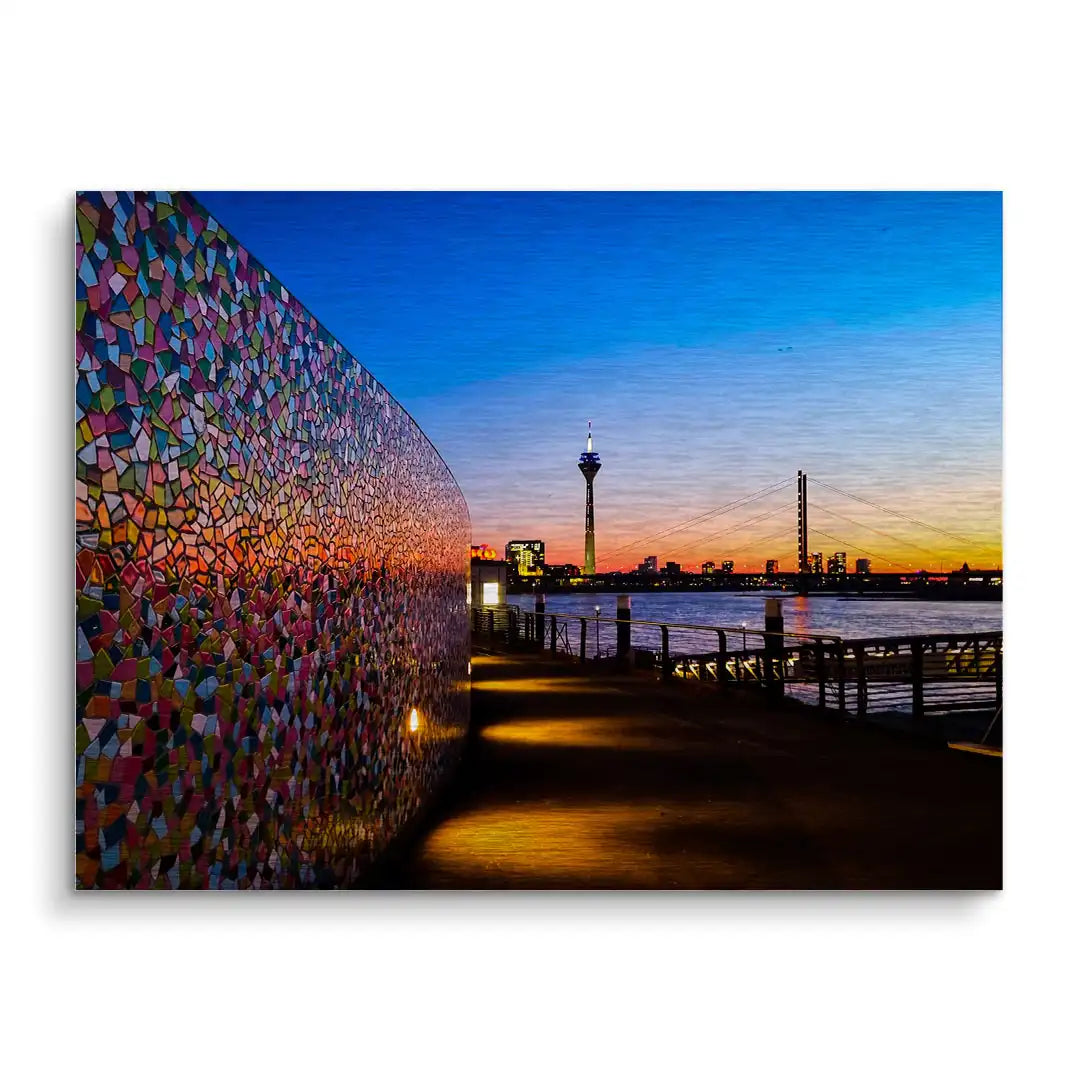 Modernes Wandbild mit buntem Mosaik, Fluss, Brücke und Fernsehturm bei Sonnenuntergang