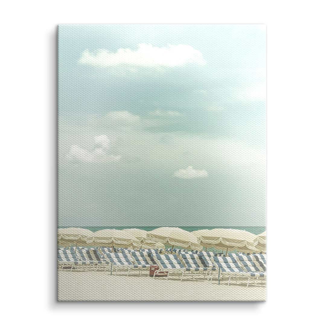 Vintage Strandbild auf Leinwand mit Liegen, Sonnenschirmen und ruhigem Meer unter blauem Himmel