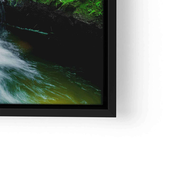 Leinwandbild mit kleinem Wasserfall, Naturmotiv in sattem Grün und schwarzem Rahmen